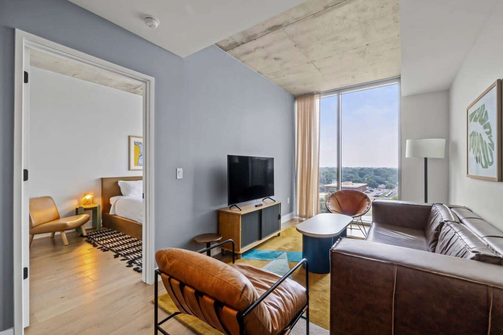 Long living room in unit 1105 showing the sofa, media console and 10-foot ceilings