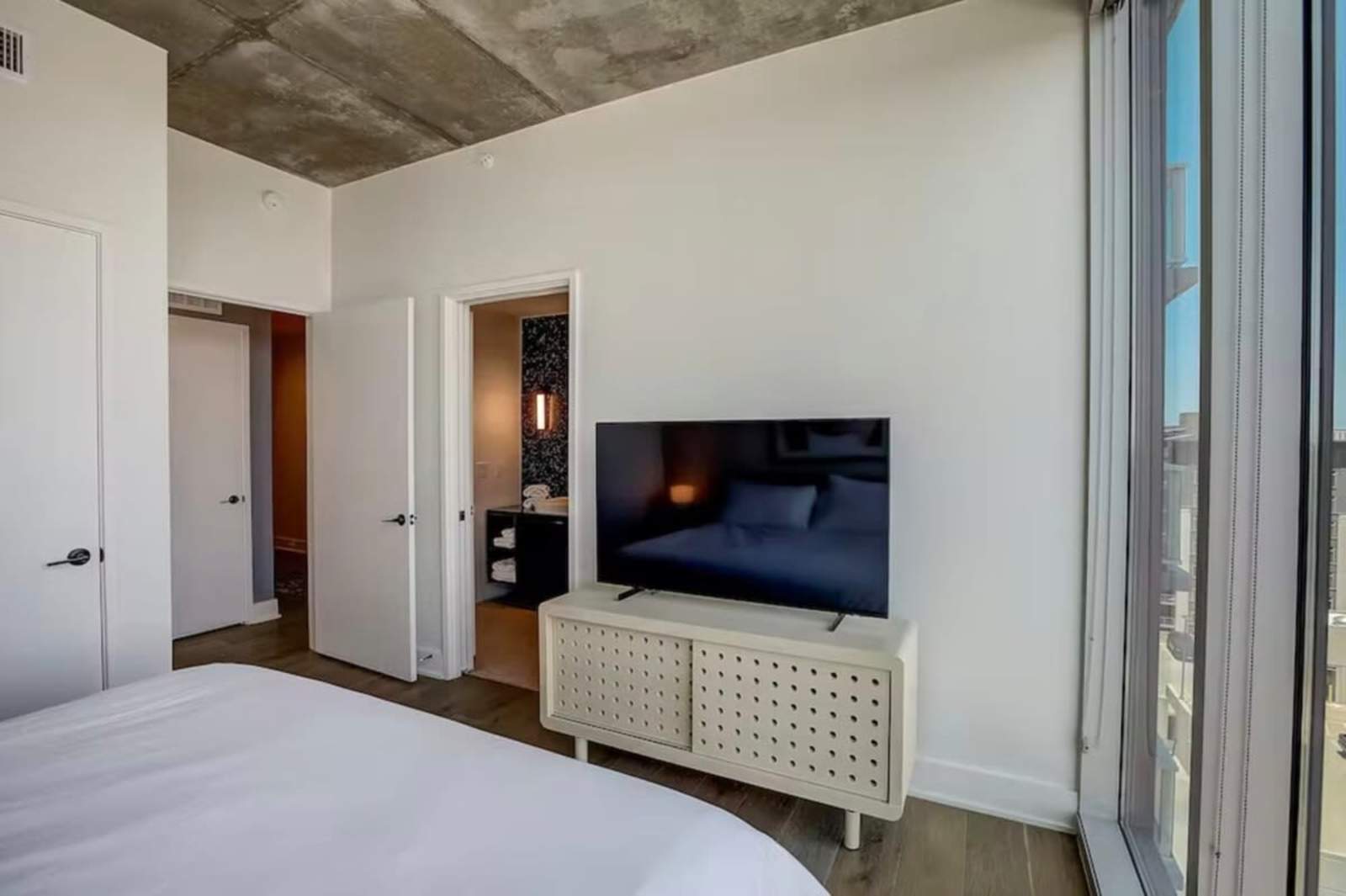 Hallway of unit 1504 leading from the entry to the bedroom, with the TV console visible