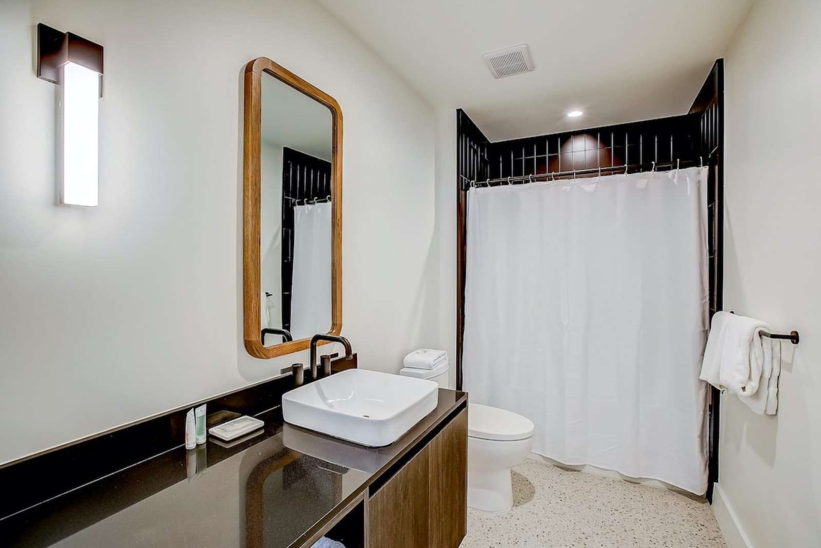 Second bathroom in unit 1406 with a vanity, mirror and bath
