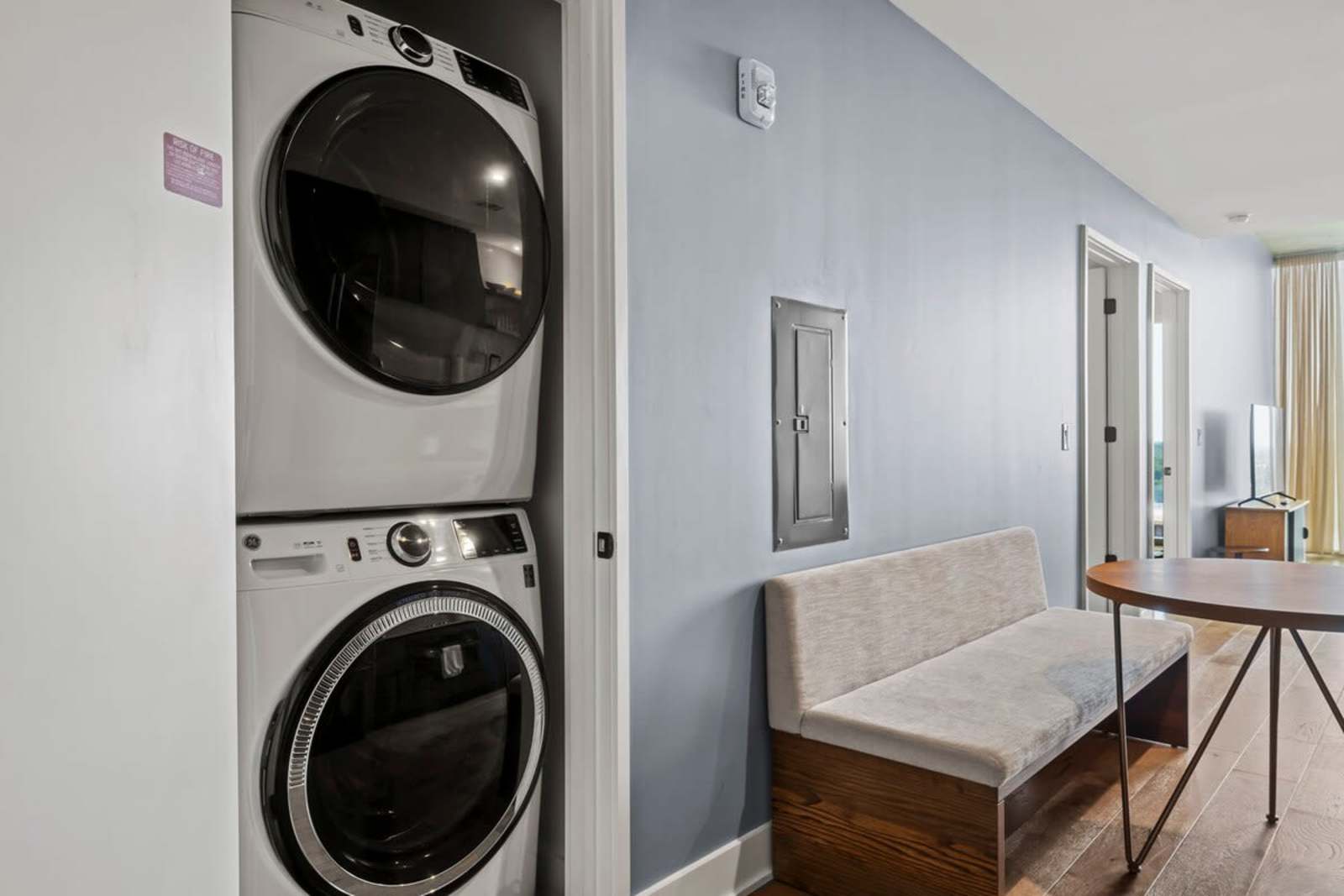 In-home stacked washer and dryer in unit 1105, beside the entry bench