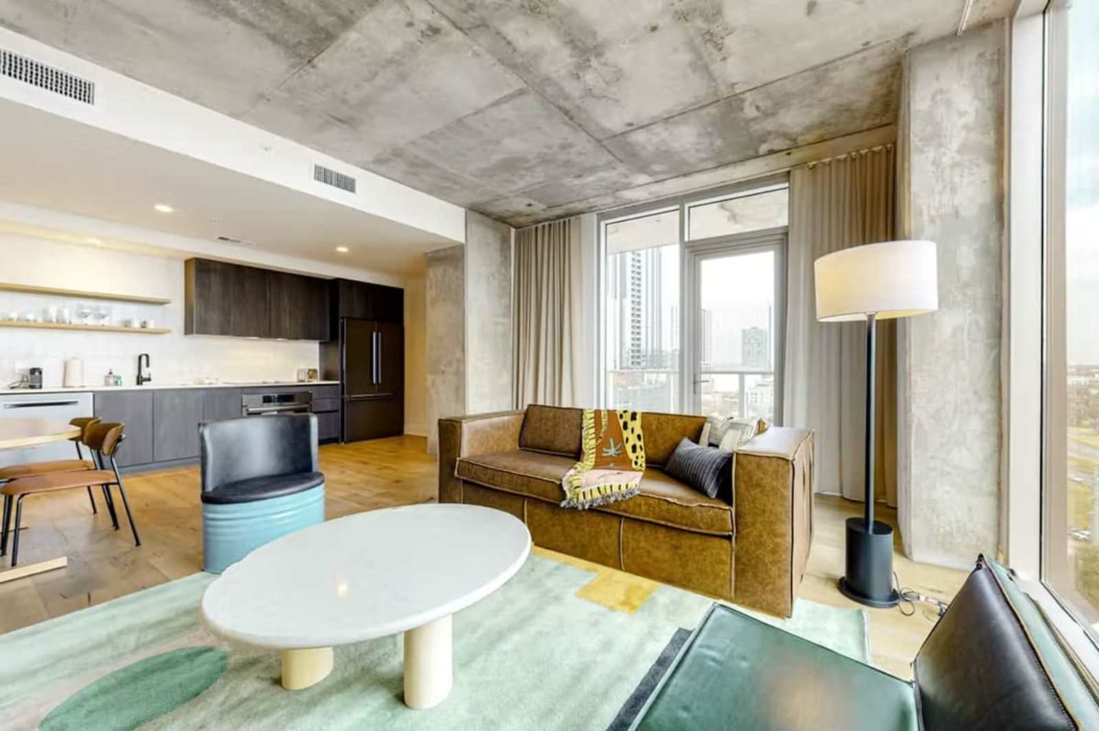 Wide view of unit 1205 showing the living room, dining table and kitchen in one open plan