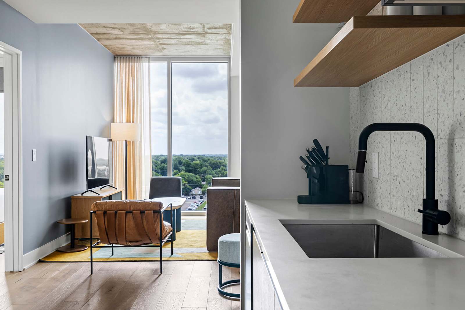 Dining and workspace corner in unit 1204 with a round table, desk chair and windows over Austin