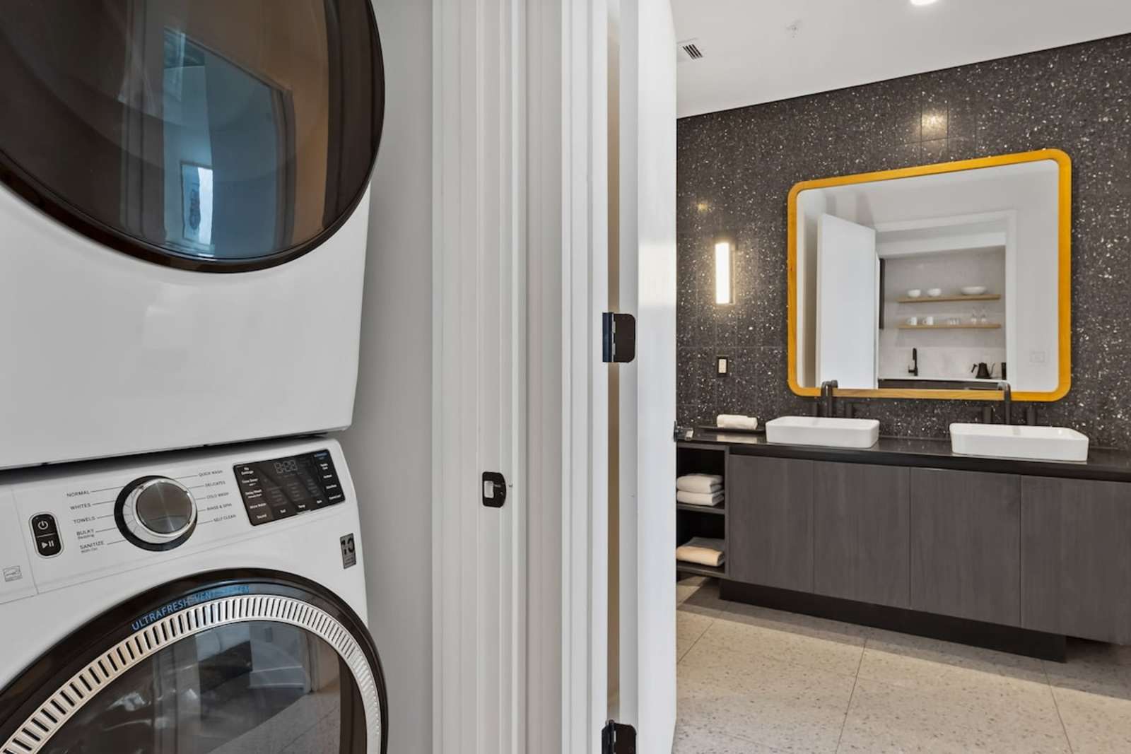 Stacked washer and dryer in unit 2006, next to the bathroom vanity